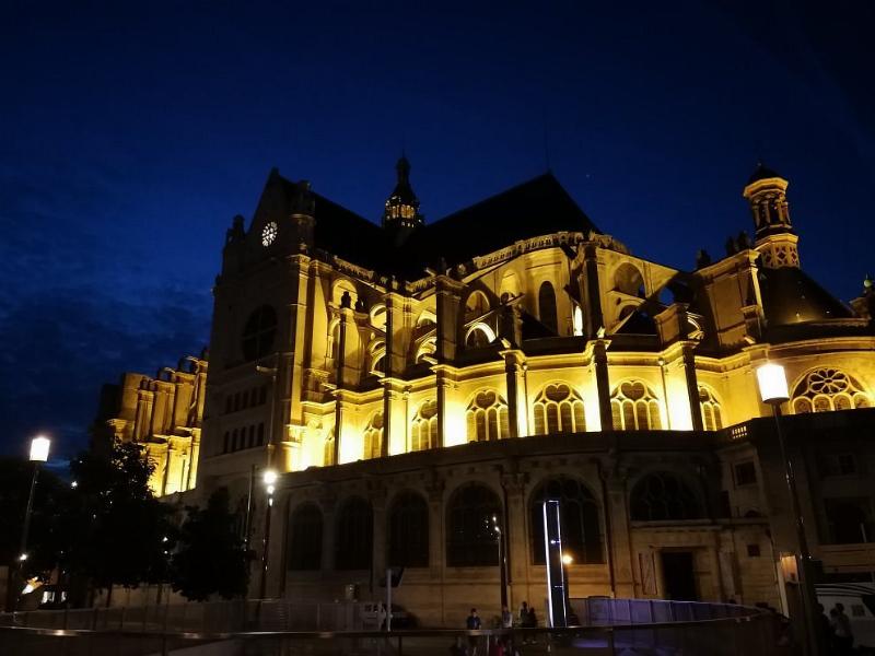 L’intérieur majestueux de l’église Saint-Eustache à Paris pendant une messe, mettant en valeur son architecture gothique et Renaissance.